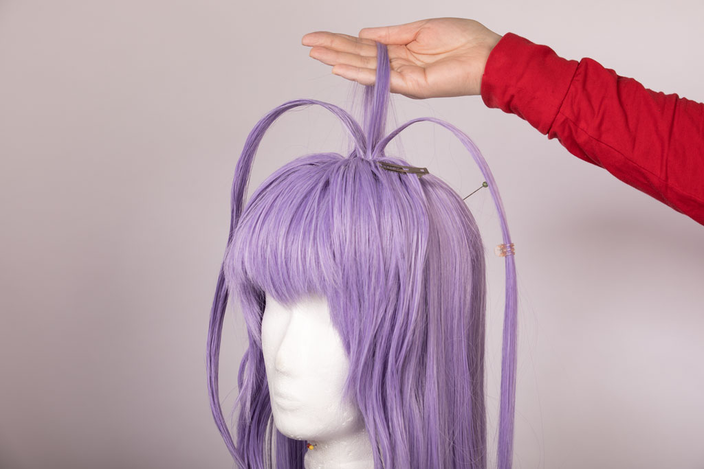 wig with long strands of hair sticking out